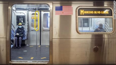 Commuters wear face masks as they ride the M train on April 10 in New York.