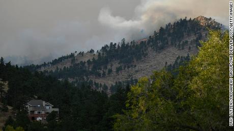  The CalWood fire burns on a hillside sending up a large plume of smoke near Buckingham Park northwest of Boulder.