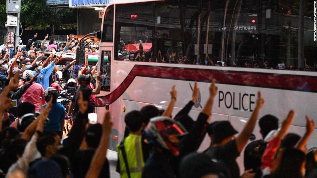 Pro-democracy protesters give the three-finger salute as a police bus passes at Wongwian Yai on October 17.