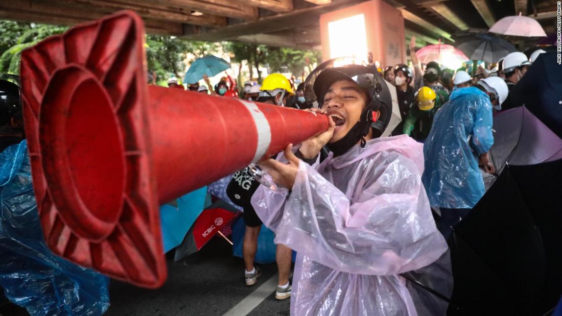 A pro-democracy protester jokingly uses a traffic cone as a loudpspeaker during an anti-government rally at Victory Monument in Bangkok on October 18.