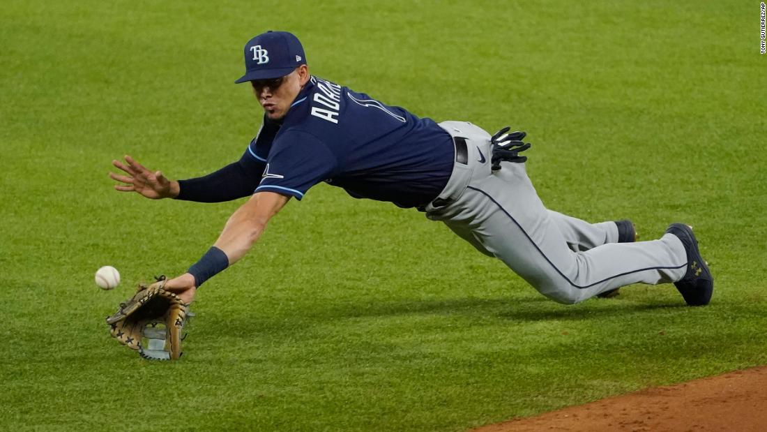 A ground ball hops over the outstretched glove of Rays shortstop Willy Adames.