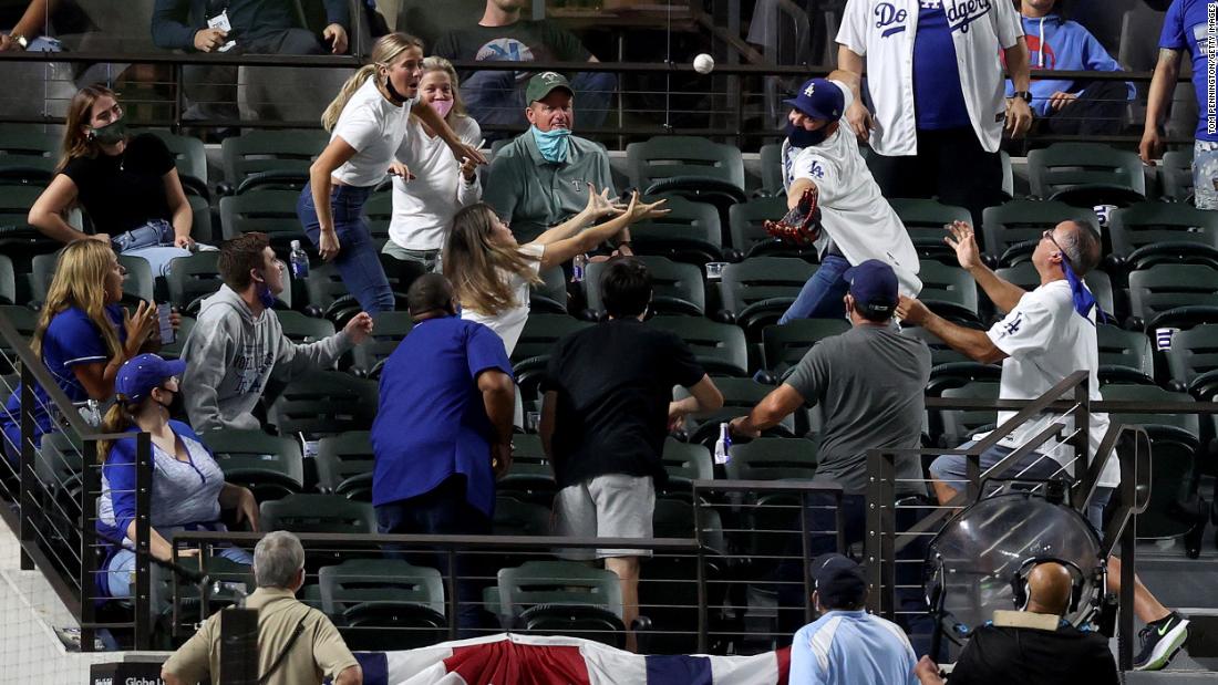Fans attempt to catch a foul ball.