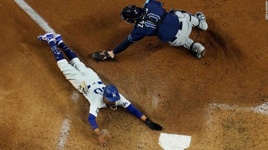 Dodgers outfielder Mookie Betts slides safely into home around the glove of Rays catcher Mike Zunino in the fifth inning.