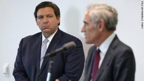 Florida Gov. Ron DeSantis, left, looks at Dr. Scott Atlas, President Donald Trump's new pandemic advisor, as he gestures during a press conference at the University of South Florida College of Medicine and Cardiology on Monday, August.  31, 2020, in Tampa, Florida. 