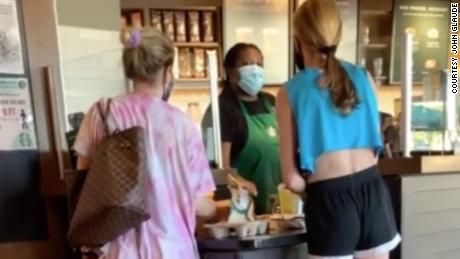 The customer, right, began yelling at the Starbucks worker when asked to pull her mask over her face.