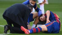 Messi receives medical attention after being tackled during the game against Real Madrid.