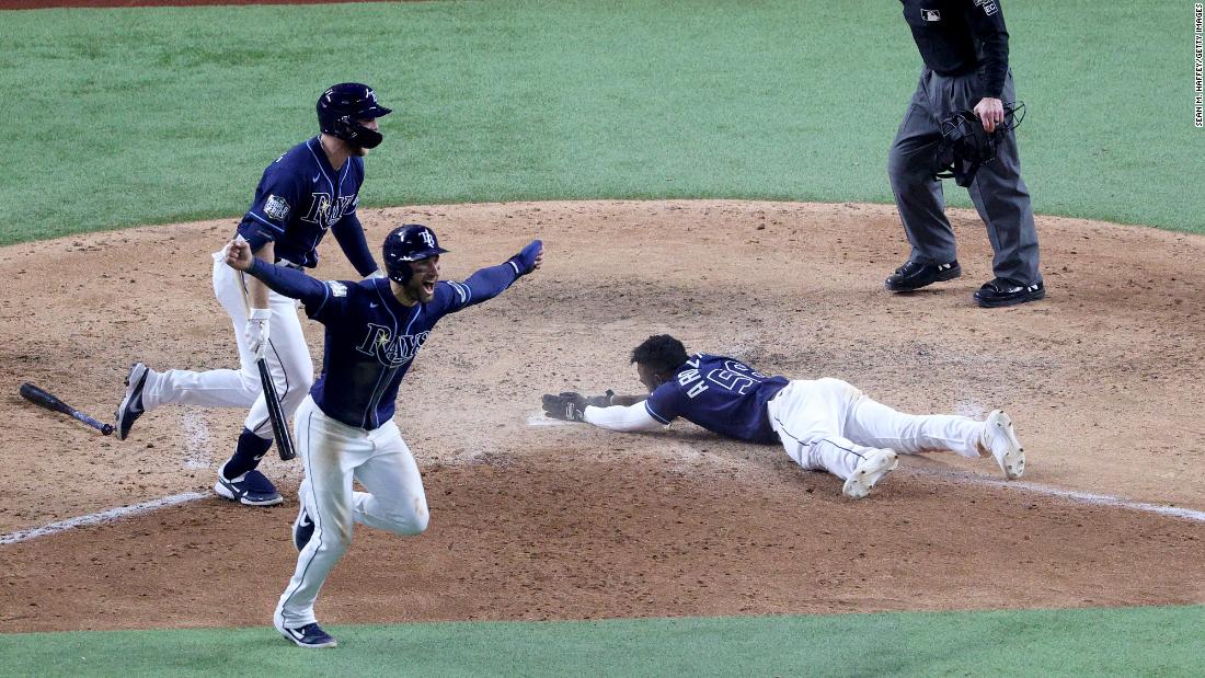 The Rays&#39; Randy Arozarena slides into home plate during the ninth inning to score the winning run in Game 4. 