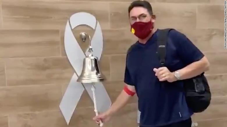 Washington Football Team coach Ron Rivera rings the bell after completing his last round of cancer treatments