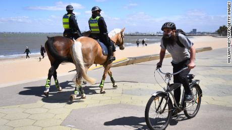 Police patrol on horseback along the St Kilda Esplanade in Melbourne on October 26, 2020. The city was previously at the epicenter of Australia&#39;s coronavirus outbreak. 
