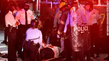 A police officer lies on the ground before being loaded into an ambulance on 52nd Street early on October 27.