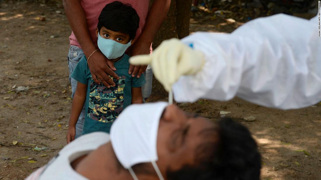 A boy watches as a health worker tests someone for Covid-19 in Hyderabad, India, on October 27.