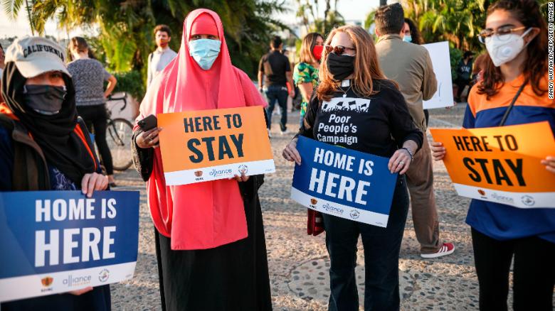 People hold signs during a rally in support of the Supreme Court&#39;s ruling in favor of the Deferred Action for Childhood Arrivals (DACA) program, in San Diego, California June 18, 2020.