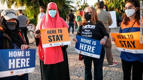 People hold signs during a rally in support of the Supreme Court&#39;s ruling in favor of the Deferred Action for Childhood Arrivals (DACA) program, in San Diego, California June 18, 2020.