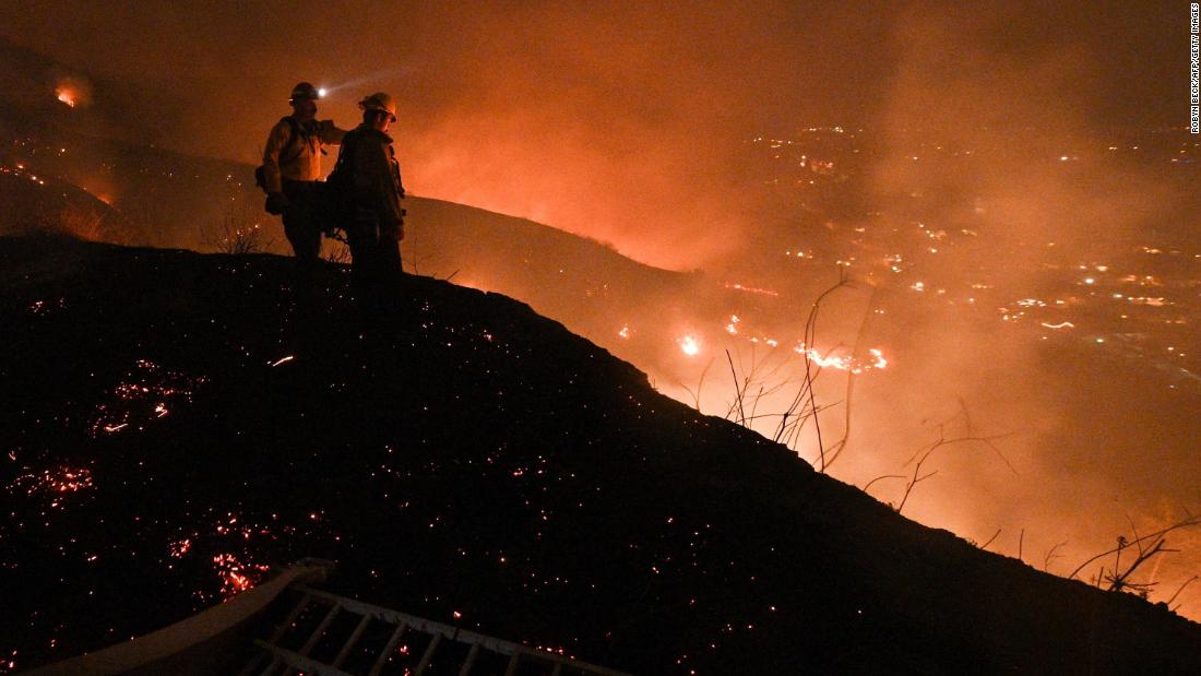 Firefighters look out over a burning hillside as they fight the Blue Ridge Fire in Yorba Linda, California, on Monday, October 26, 2020.