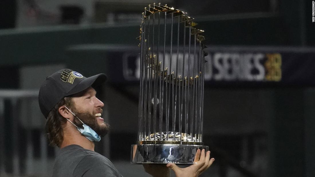 Los Angeles Dodgers pitcher Clayton Kershaw holds up the trophy after the team&#39;s win.