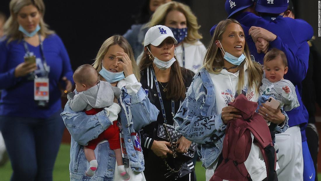 Family members of the Los Angeles Dodgers walk on the field to celebrate with the team.