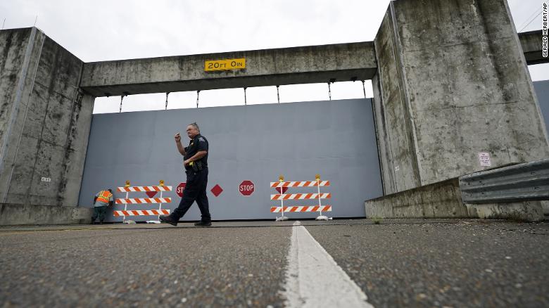 A Plaquemines Parish sheriff&#39;s deputy walks away after workers closed a floodwall gate on Highway 39 in Poydras, Louisiana, on  Wednesday, October 28.