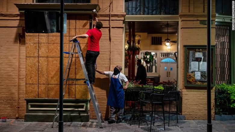 General manager Gaige Rodriguez, left, and cook Michael Dillon board up windows at Pere Antoine Restaurant in New Orleans in preparation for Hurricane Zeta, which made landfall Wednesday.