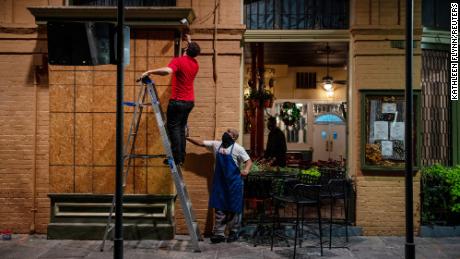 General manager Gaige Rodriguez, left, and cook Michael Dillon board up windows at Pere Antoine Restaurant in New Orleans in preparation for Hurricane Zeta, which made landfall Wednesday.