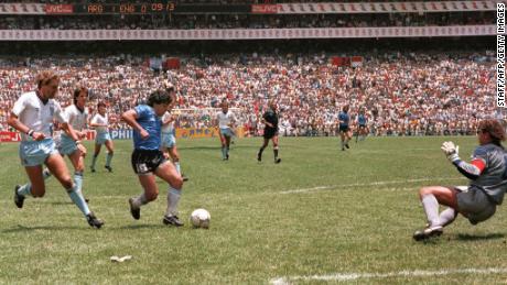 Maradona runs past England defender Terry Butcher (left) while dripping goalkeeper Peter Shilton (right) to score his second goal against England at the 1986 World Cup.