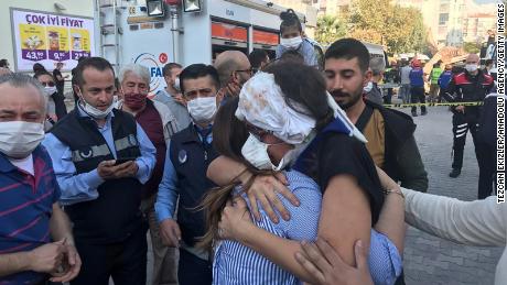 A wounded woman hugs her relative after being rescued from debris of a building in Bornova district of Izmir on Friday. 