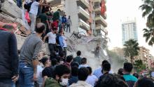 People try to save residents trapped in the debris of a collapsed building in Izmir, Turkey, on Friday, October 30.
