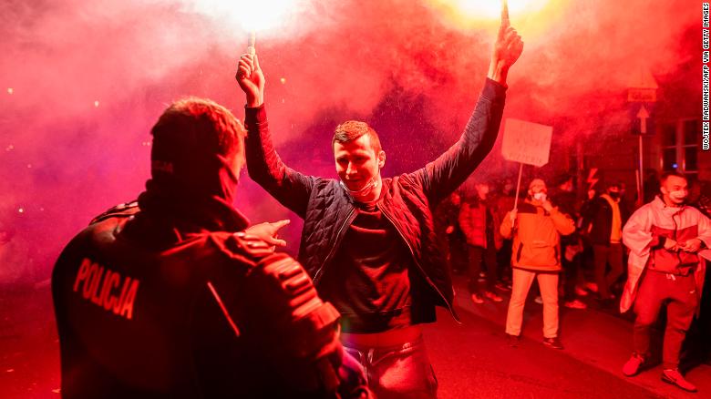 A demonstrator in Warsaw holds flares as hundreds of thousands took to the streets this week to voice their opposition to the tightening of Poland&#39;s abortion law.
