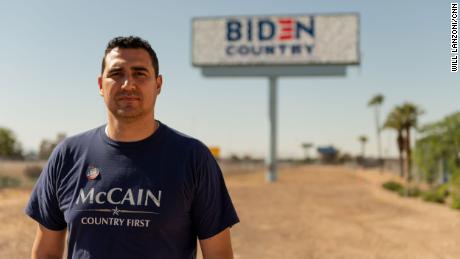 Yasser Sanchez stands in front of a billboard he funded off the side of Interstate 10 in Phoenix.