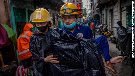 Rescue workers carry a sick person as they evacuate before Typhoon Goni hits on November 1 in Manila, Philippines.