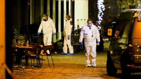 Three persons investigate at the scene following gunfire on people in the Austrian capital Vienna, Tuesday, Nov. 3, 2020.