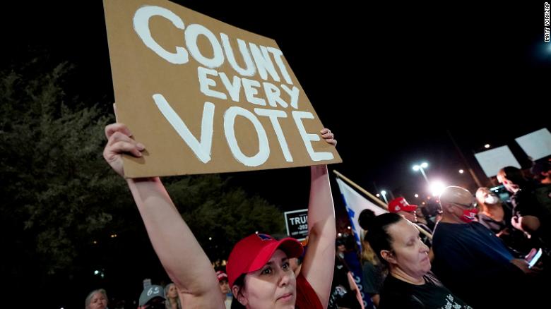 Ένας υποστηρικτής του Προέδρου Ντόναλντ Τραμπ κατέχει ένα & quot; Μετρήστε κάθε ψήφο & quot; υπογράψτε σε συγκέντρωση την Τετάρτη το βράδυ έξω από το κέντρο καταμέτρησης ψήφων της κομητείας Maricopa στο Φοίνιξ.