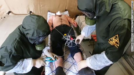 Medical staff examine a person on May 25, 2020, at a multifunctional field hospital for coronavirus patients built by the Russian Defense Ministry in Buynaksk, Dagestan.
