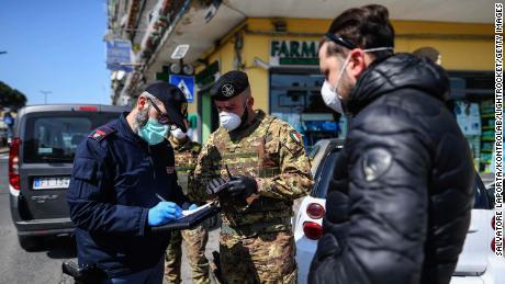 Italian Army soldiers and police carry out a document check on 23 March, 2020, in Naples, as limits are imposed on people's freedom of movement.