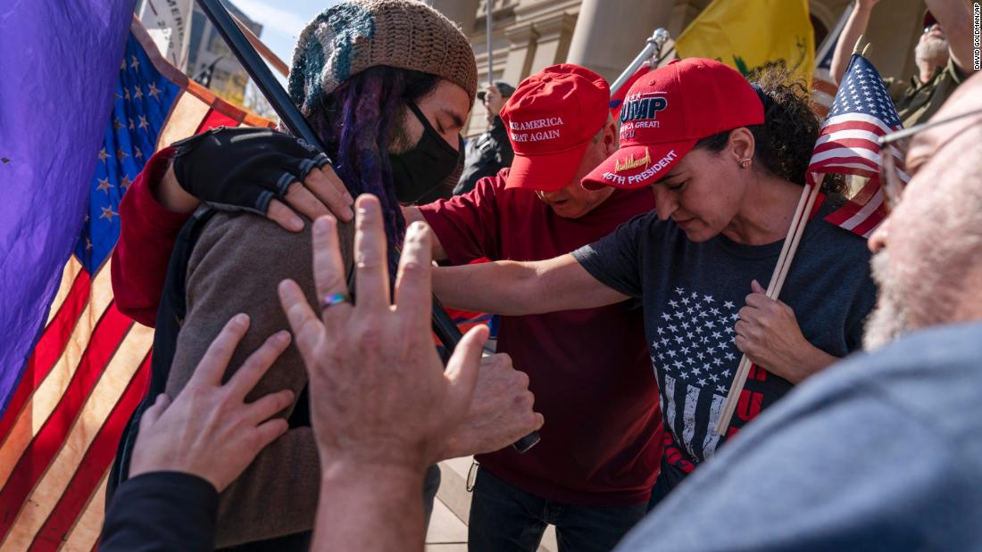 Trump supporters pray with a counterprotester in Lansing, Michigan, after Biden was projected as the winner.