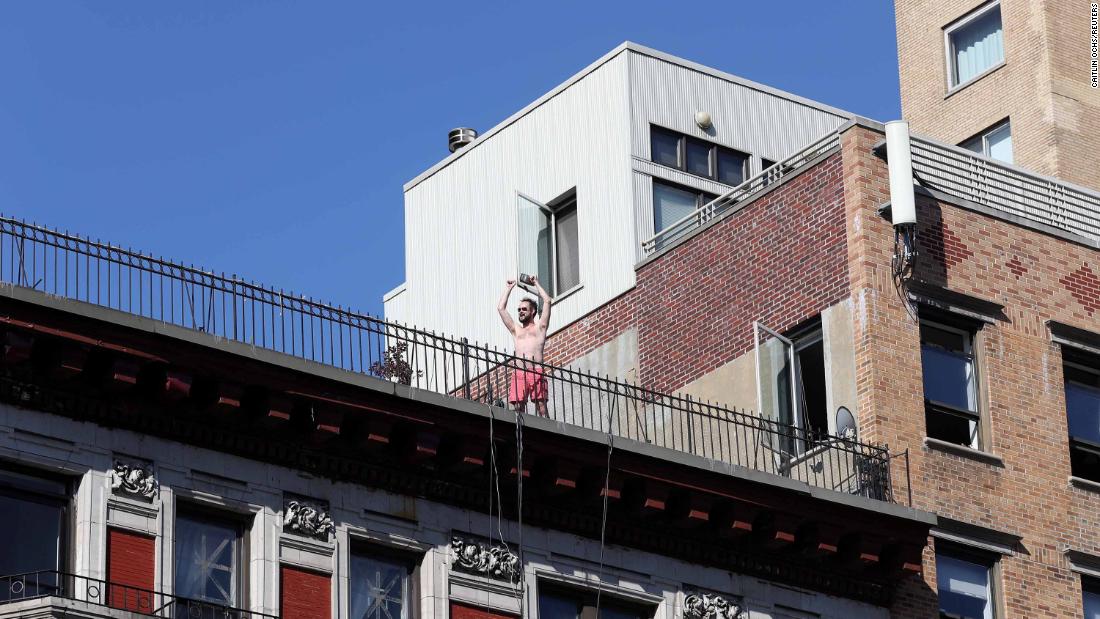 A man reacts from a rooftop in New York.