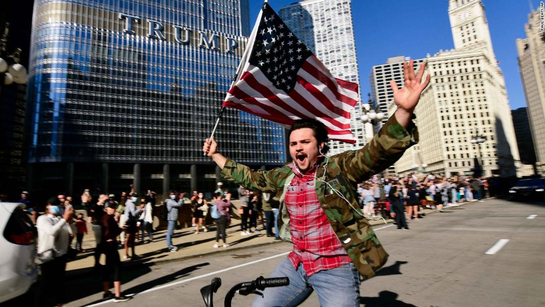 A Biden supporter celebrates while riding a bike outside Trump Tower in Chicago.