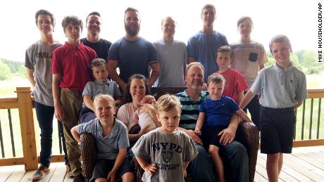 The Schwandt family poses for a photo in 2018 after welcoming their 14th son. Standing, from left, are Tommy, Calvin, Drew, Tyler, Zach, Brandon, Gabe, Vinny and Wesley. Seated, starting at upper left, are Charlie, Luke, mother Kateri holding Finley, father Jay with Tucker and Francisco in the foreground.