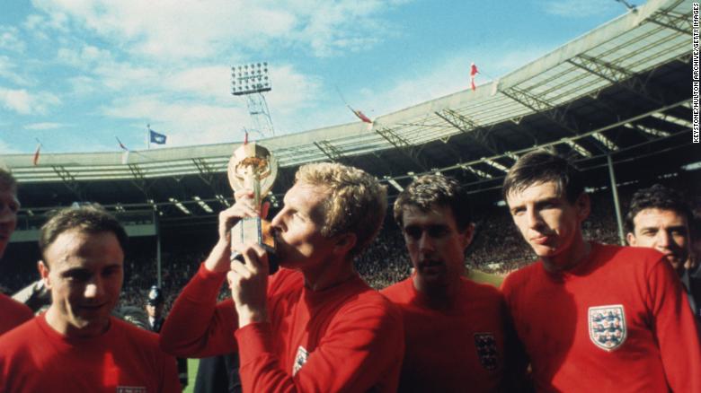 England captain Bobby Moore kissing the Jules Rimet trophy as the team celebrate winning the 1966 World Cup final against Germany at Wembley Stadium. His team mates are, left to right, George Cohen, Geoff Hurst and Martin Peters, 30th July 1966. 