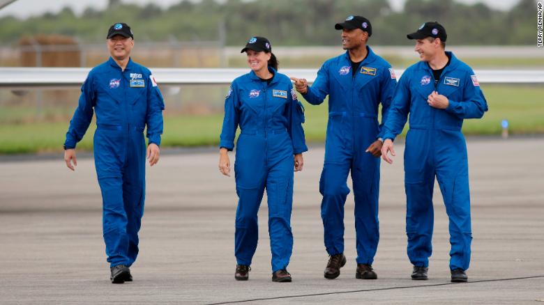 From left to right, astronauts Soichi Noguchi, Shannon Walker, Victor Glover and Michael Hopkins walk to the microphone at the Kennedy Space Center on Sunday.