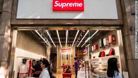  Pedestrians walk past an American skateboarding shop and clothing brand Supreme store in Shanghai on September 9, 2019.