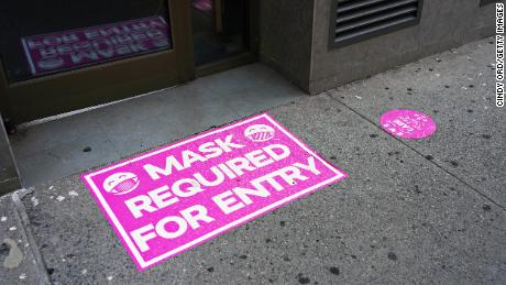 A 'mask required for entry' sign is displayed at the entry to a retail store on August 23, 2020 in New York City. 