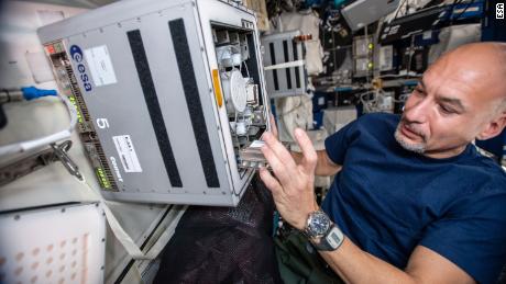 European Space Agency astronaut Luca Parmitano on the International Space Station is shown here conducting the experiment with the biomining reactors.