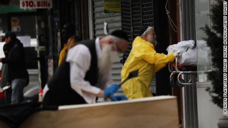 Orthodox Jewish men move a wooden casket from a hearse at a funeral home on April 5, 2020 in the Brooklyn borough of New York City. 