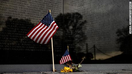 A flower and two American flags are left at the base of the Vietnam Veterans Memorial Wall on Veterans Day on November 11, 2020 in Washington, DC