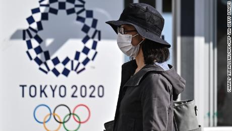 A woman walks past a Tokyo 2020 poster during a test of potential spectator and games screening measures ahead of the Tokyo 2020 Olympic Games, now postponed until July 2021 due to the COVID-19 coronavirus pandemic, in Tokyo on October 21, 2020. (Photo by Charly TRIBALLEAU / AFP) / TO GO WITH OLYMPICS PACKAGE (Photo by CHARLY TRIBALLEAU/AFP via Getty Images)