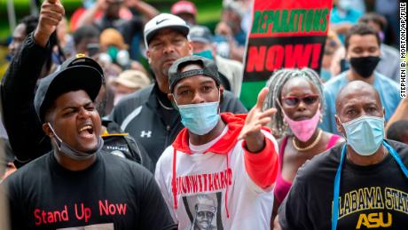 A group of protesters shout at two Cobb County investigators outside the Glynn County Courthouse during a June 4 preliminary hearing for the suspects in Arbery&#39;s shooting.