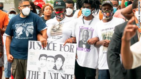 Ahmaud Arbery&#39;s aunt Theawanza Brooks, center left, joins family members and supporters for a march in Glynn County on May 16 after a rally to protest his shooting.