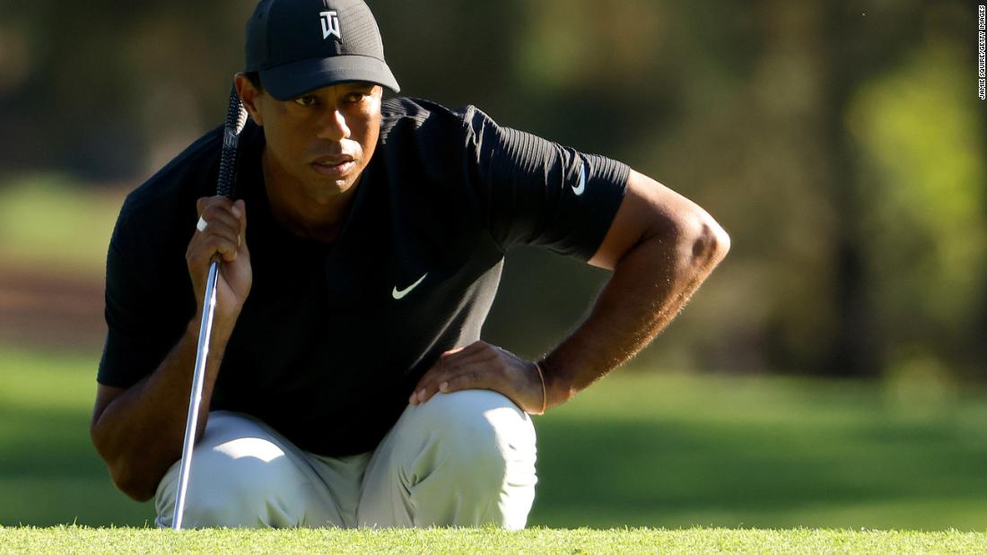 Tiger Woods of the United States lines up a putt on the third green, which he three-putted for a bogey.