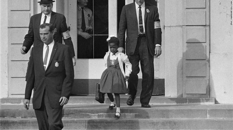 US deputy marshals escort 6-year-old Ruby Bridges from William Frantz Elementary School in New Orleans. 