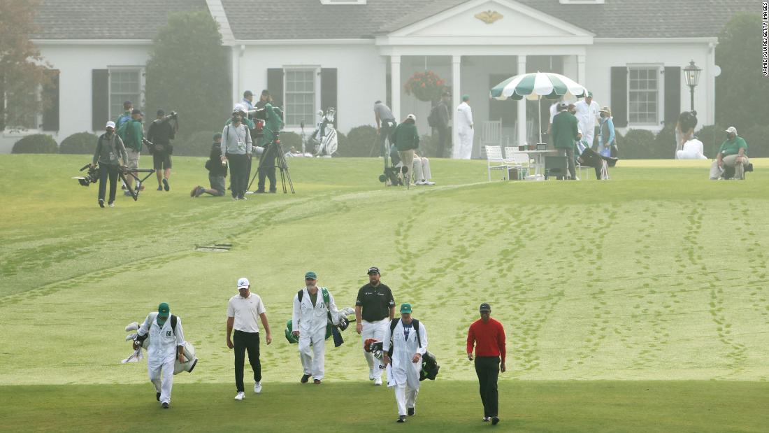 Tiger Woods of the United States, Scottie Scheffler of the United States and Shane Lowry of Ireland walk from the first tee on the final round.